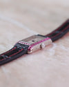 Crown-side profile of the Cartier Tank Allongée with its faceted crown and pink sapphire-set case.