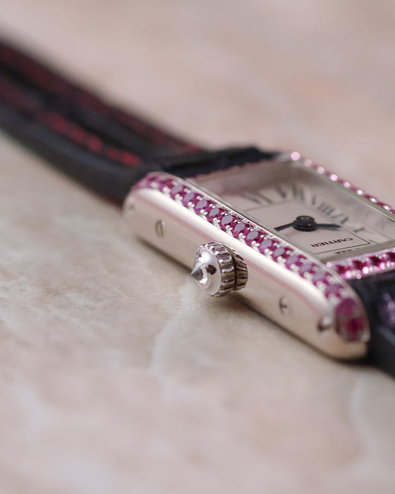 Macro view of the Cartier Tank Allongée crown and pink sapphire-set white gold case.