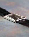 Side profile of the vintage Piaget Ref. 9150 showing its slim rectangular white gold case and black leather strap.