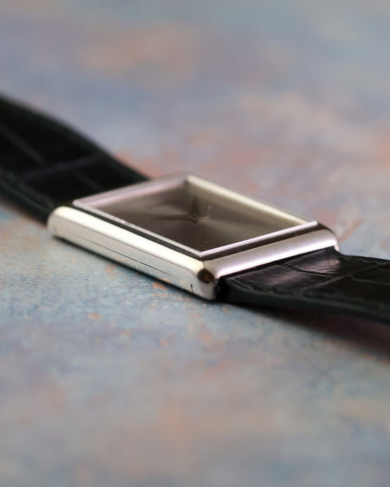 Side profile of the vintage Piaget Ref. 9150 showing its slim rectangular white gold case and black leather strap.