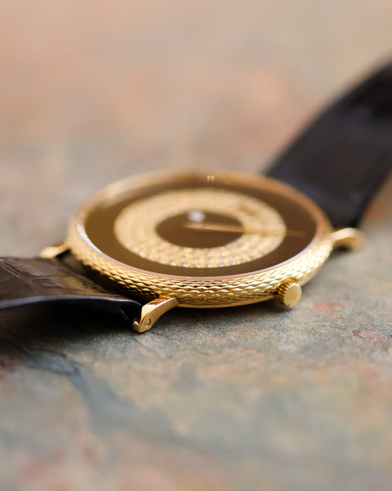 Side profile of the Piaget Ref. 9026 showing its textured 18K yellow gold case, black onyx dial and diamond-set mystery-hour display.