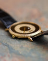 Low-angle view of the Piaget 9026 highlighting the engraved yellow gold case band, crown and black leather strap.