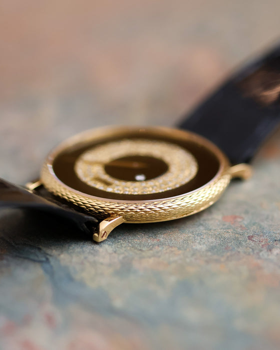Macro side view of the Piaget Ref. 9026 showing the textured gold case and layered onyx and diamond dial.