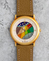 Blancpain Ref. 0021 in 18K yellow gold with colourful cloisonné enamel dial, photographed front-on on a stone background.