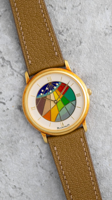 Angled view of the Blancpain Ref. 0021 showing its geometric multicoloured cloisonné enamel dial and yellow-gold case.