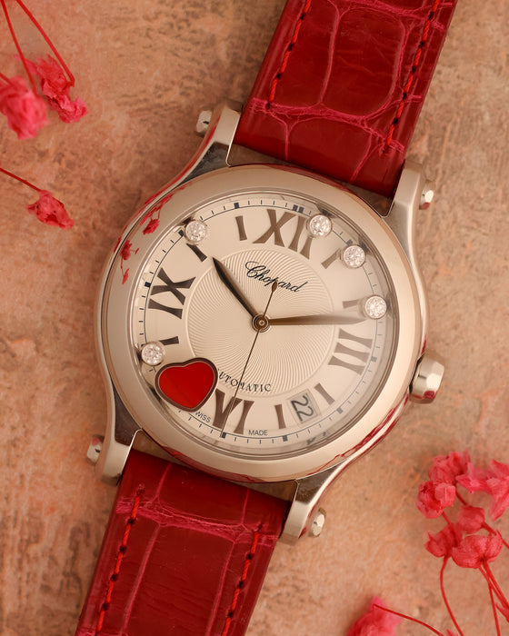 Angled view of the Chopard Happy Sport Cortina 50th Anniversary showing its white guilloché dial, mobile diamonds and red heart.