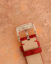 Reverse of the signed Chopard stainless-steel pin buckle and red alligator strap.
