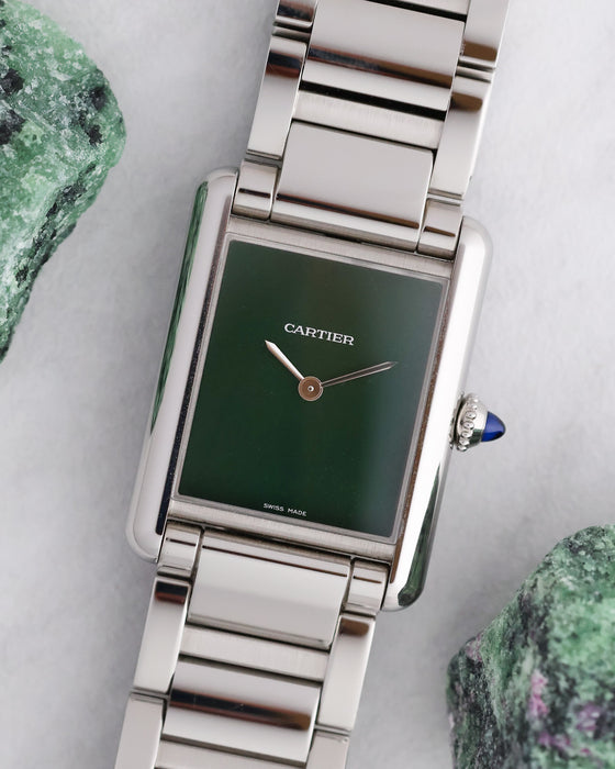 Cartier Tank Must WSTA0056 with minimalist green lacquer dial and stainless steel Cartier bracelet photographed beside green mineral specimens.