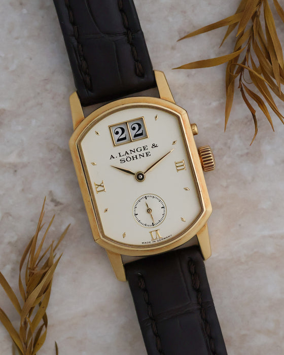 Close-up of the Arkade 103.021 showing its architectural yellow-gold case and ivory dial.