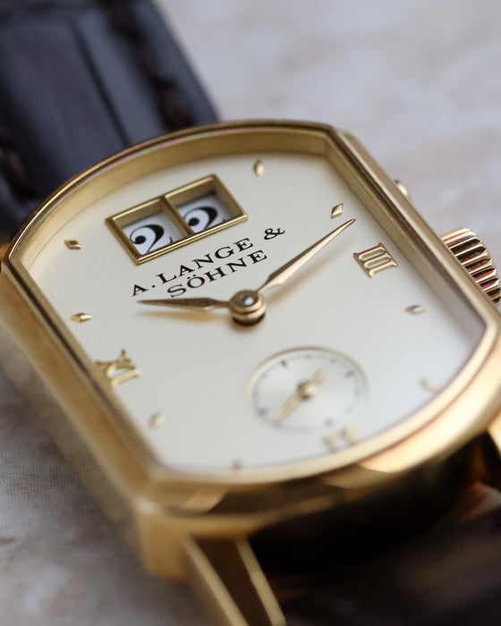 Macro view of the Arkade dial highlighting the double-window outsize date and applied gold markers.