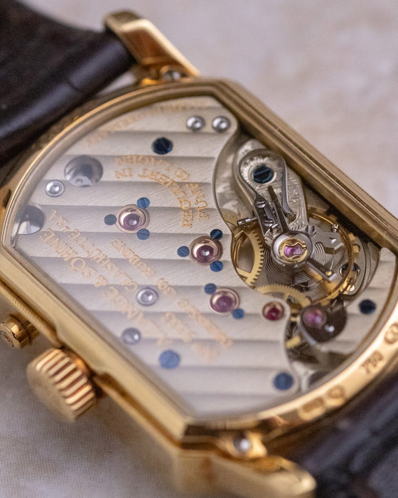 Macro view through the sapphire caseback showing the decorated calibre L911.4 and hand-engraved balance cock.