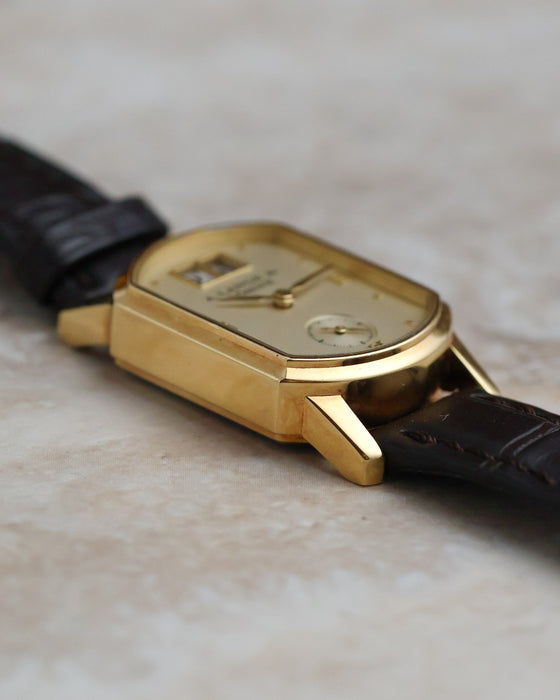Side profile of the yellow-gold Arkade case showing its polished surfaces and angular lugs.
