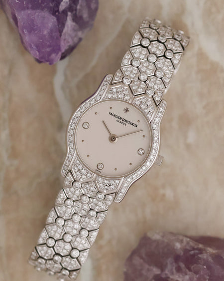 Vacheron Constantin diamond watch photographed beside amethyst stones, showing its full bracelet design.