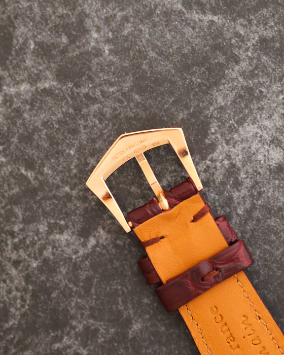 Signed Patek Philippe 18K rose-gold pin buckle fitted to the burgundy leather strap.