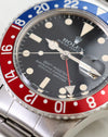 Close-up of Rolex GMT-Master 1675 dial, tritium plots, hands and red bezel.