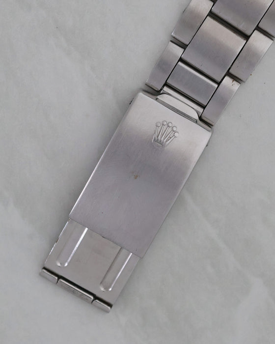 Exterior Rolex-signed clasp on folded stainless-steel Oyster bracelet.