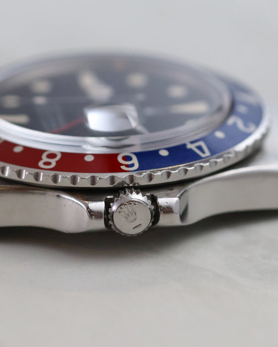 Macro side view of Rolex GMT-Master 1675 crown and acrylic crystal.
