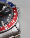 Close-up of red Pepsi bezel, GMT hand and lower-right lug.