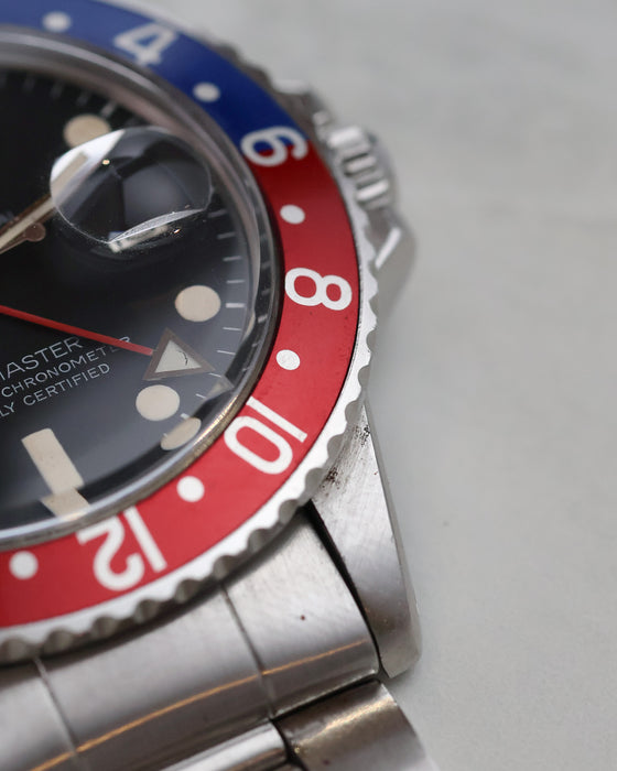 Close-up of red Pepsi bezel, GMT hand and lower-right lug.