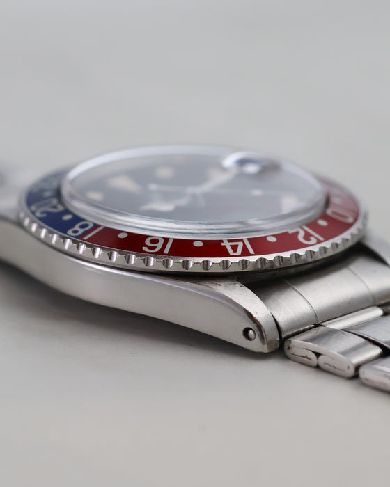 Side profile of Rolex GMT-Master 1675 showing domed acrylic crystal and folded bracelet.