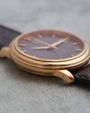 Side profile of the 18K rose-gold Omega De Ville showing its stepped bezel and tapered lugs.