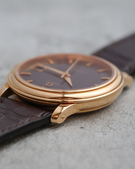 Side view of the polished 18K rose-gold case and curved lugs.