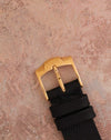 Signed Piaget 18K rose-gold buckle fitted to the black leather strap.