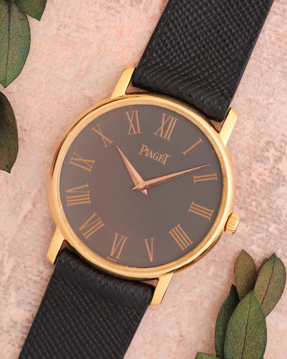 Angled view of the Piaget 80035 showing its grey dial, rose-gold Roman numerals and slim round case.