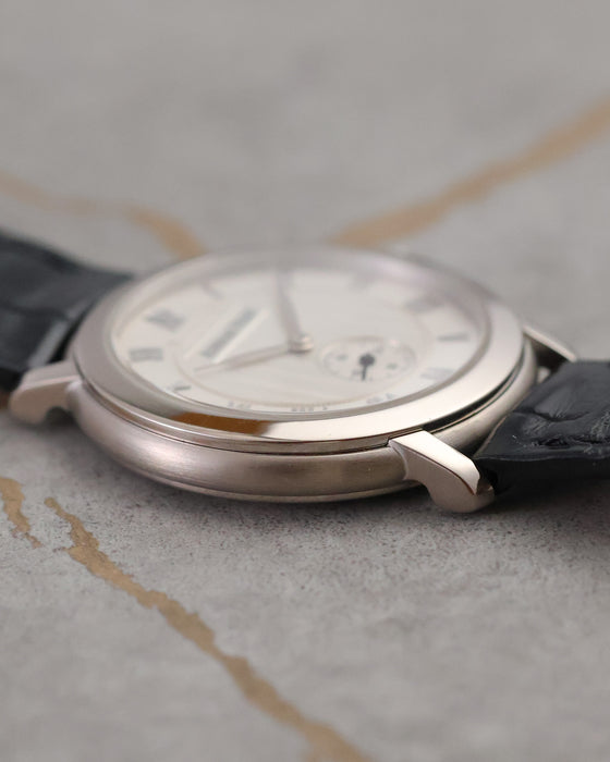 Side profile of the Audemars Piguet Jules Audemars 15056BC showing its polished white-gold bezel, brushed caseband and black leather strap.