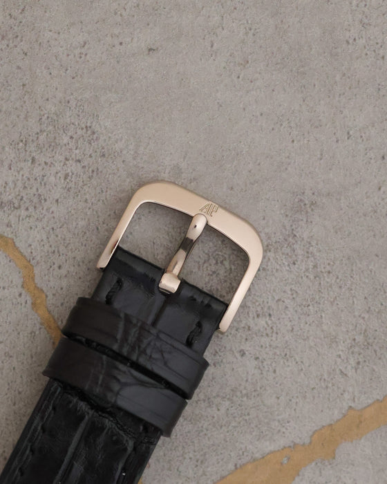 Signed 18K white-gold Audemars Piguet pin buckle fitted to the black leather strap.