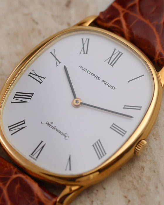 Close-up of the white dial with elongated Roman numerals, black hands and cursive Automatic signature.