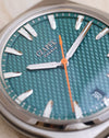 Macro photograph of the Viridian Green flinqué dial with applied indices and full-orange seconds hand.