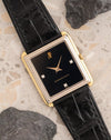 Angled view of the vintage Audemars Piguet showing its black dial, three diamond markers and contrasting yellow and white gold case.