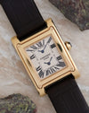 Cartier Tank à Vis Dual Time photographed with its yellow-gold case, guilloché dial and black leather strap.
