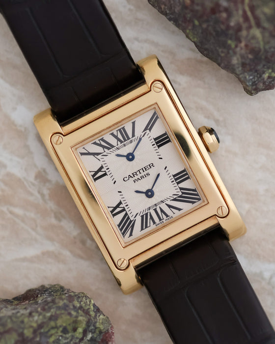 Cartier Tank à Vis Dual Time photographed with its yellow-gold case, guilloché dial and black leather strap.