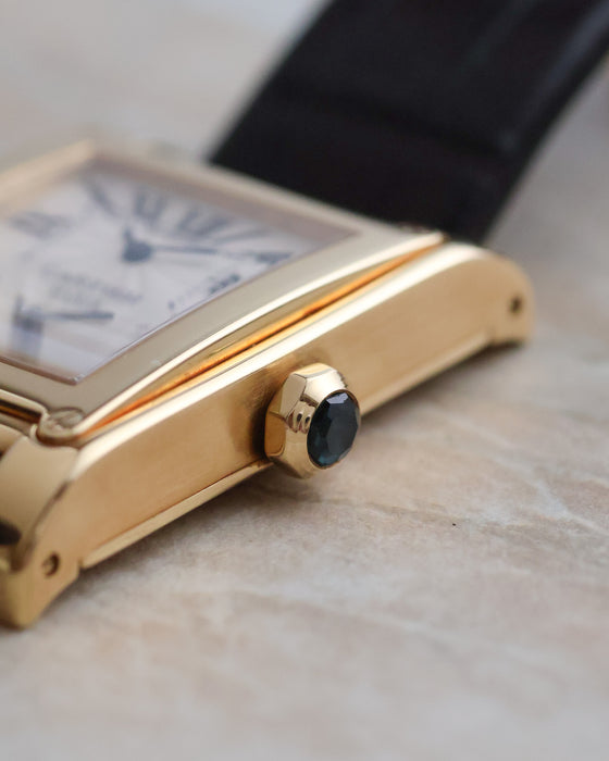 Side profile of the 18K yellow-gold Tank à Vis showing its faceted sapphire-set crown.