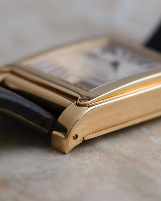 Side view highlighting the brushed case flank and polished lug of the yellow-gold Tank à Vis.