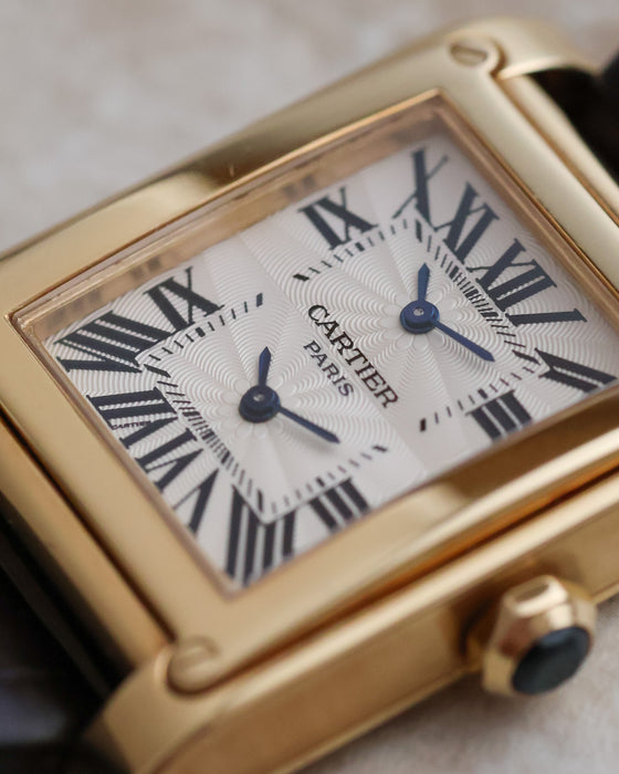 Macro photograph of the Dual Time guilloché dial with Roman numerals and blued-steel hands.
