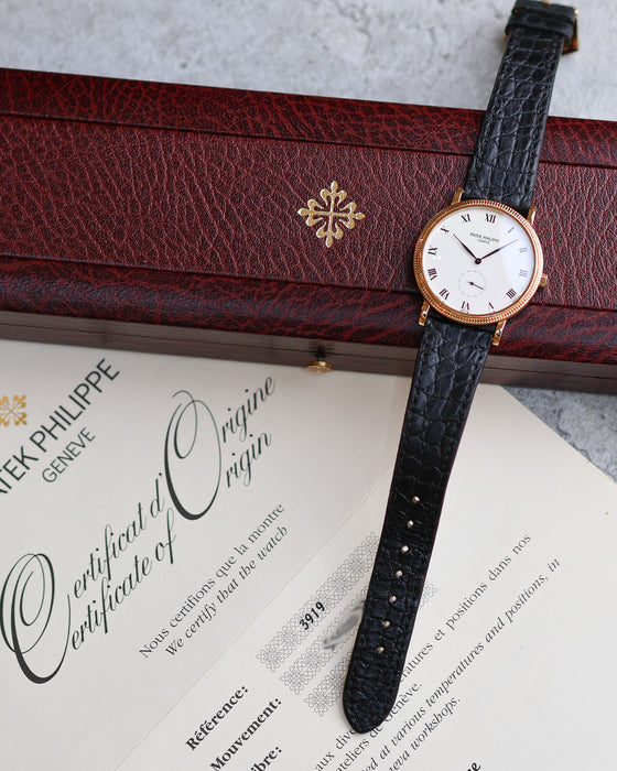 Patek Philippe Calatrava ref. 3919J in yellow gold displayed with its original presentation box and Certificate of Origin.