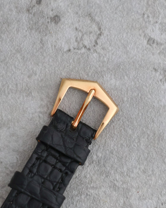 Original 18K yellow gold Patek Philippe tang buckle fitted to the black leather strap.