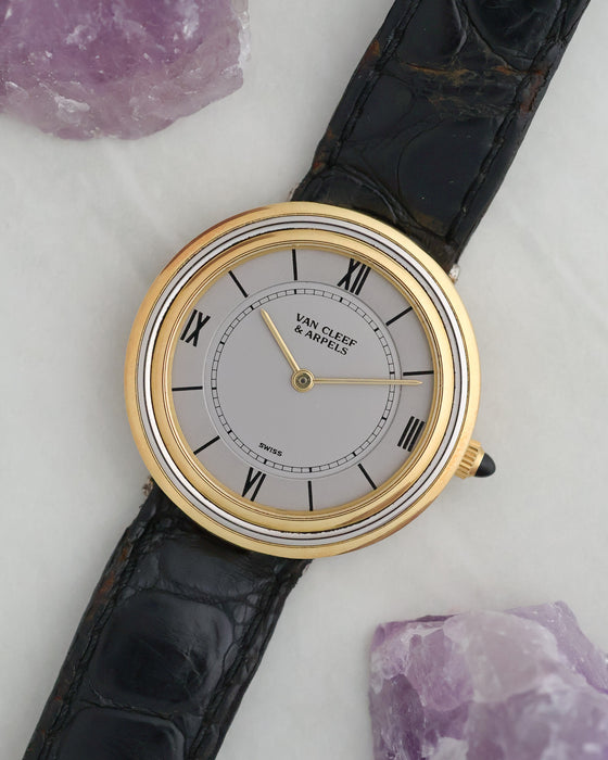 Angled view of the two-tone Van Cleef & Arpels Disco Volante with silver dial and concentric case.