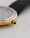 Close-up of the black cabochon-set crown on the 18K yellow gold case.