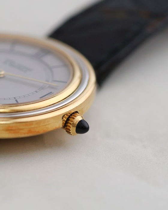 Close-up of the black cabochon-set crown on the 18K yellow gold case.
