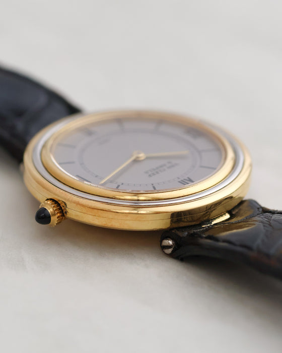 Low-angle view showing the circular profile, articulated lugs and cabochon crown.