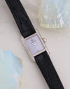Full angled view of the Cartier Mini Tank in white gold with diamond-set brancards and black leather strap.