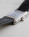 Close-up of the Cartier Mini Tank showing the curved diamond-set case edge and original black leather strap.
