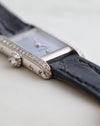 Detailed side view of the Cartier Mini Tank showing the diamond-set crown, polished white gold case and chequered dial.