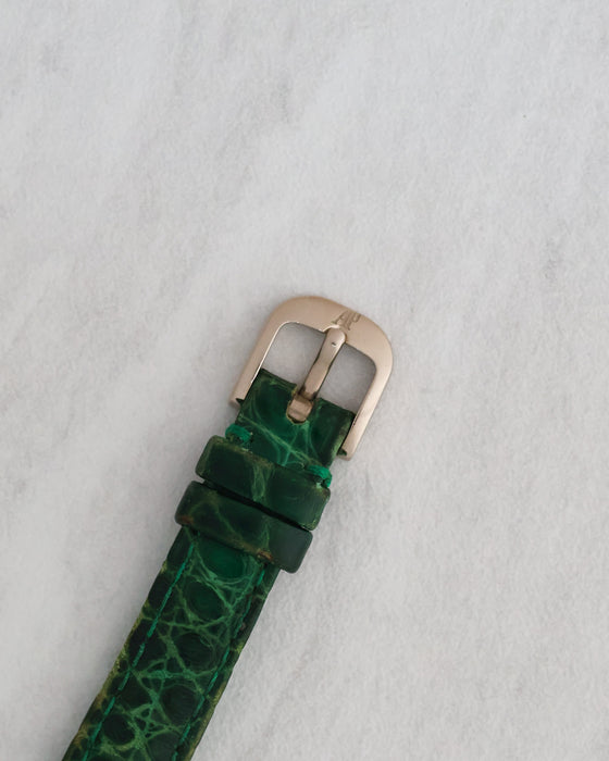 Original Audemars Piguet white gold pin buckle fitted to a green textured leather strap.