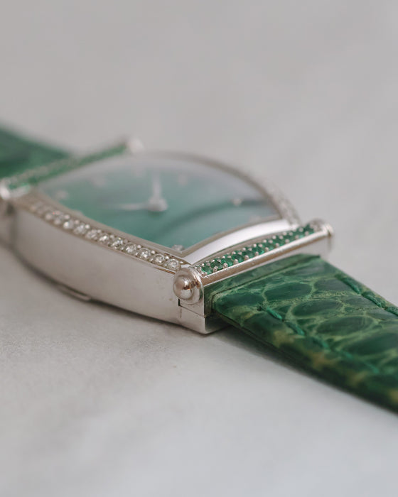 Low-angle side view highlighting the tonneau case curvature, polished white gold surfaces and gem-set details.
