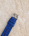 Close-up of the original Gérald Genta stainless steel pin buckle and blue textured leather strap.